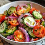 Marinated Cucumbers, Onions, and Tomatoes. A vibrant bowl of thinly sliced cucumbers, red onions