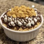 S’mores dip with layers of chocolate, marshmallow, and graham crackers.