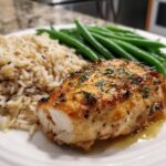 Baked chicken breast with lemon-garlic, served alongside steamed green beans and wild rice.